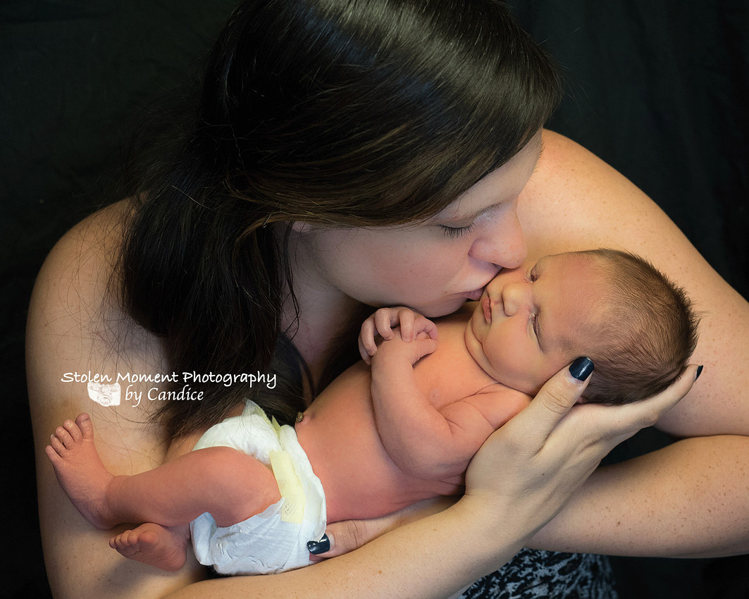Mom kissing her newborn