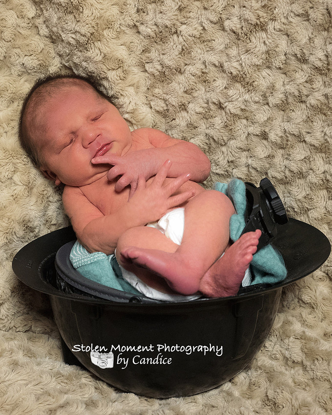 baby sleeping in his dad's hard hat