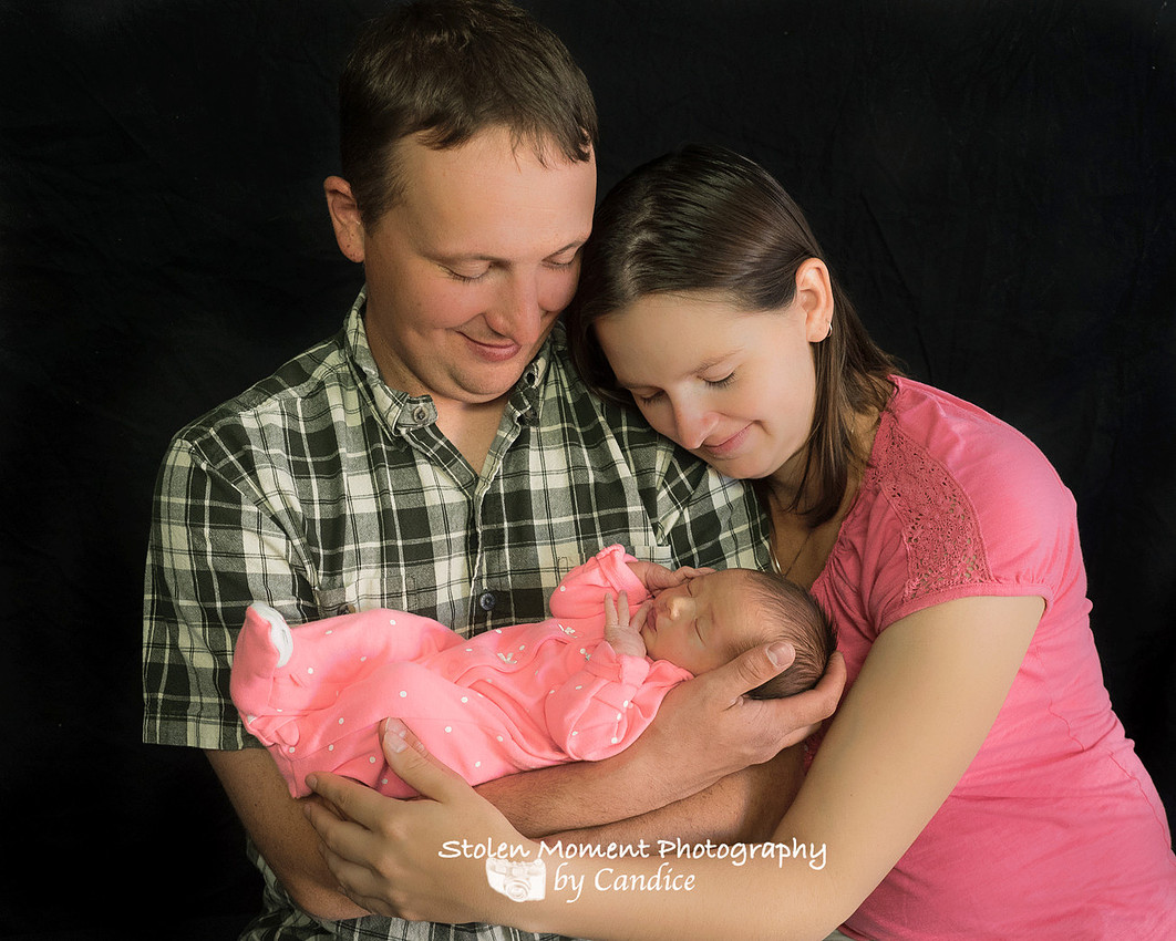 beautiful shot of mom, dad and newborn daughter 