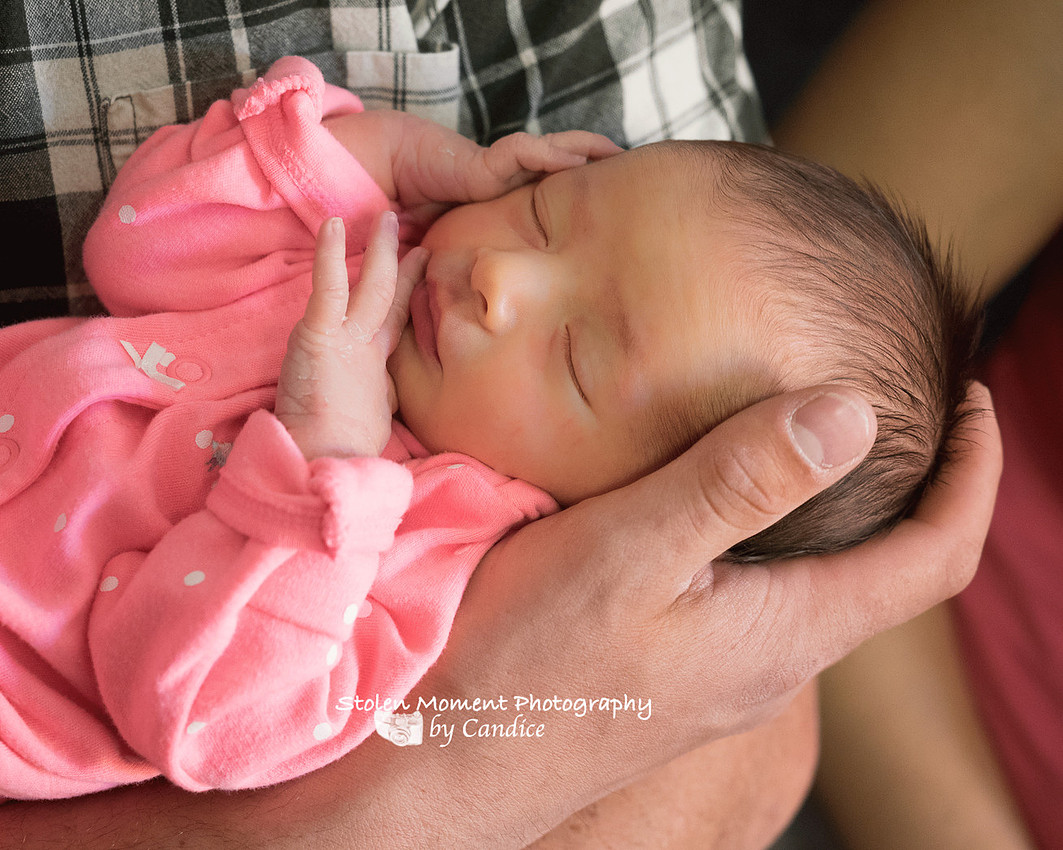 close up of newborn girl's face being held by her dad