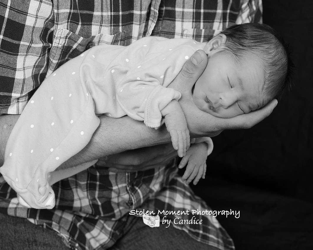 black and white photo of newborn in her dad's arms