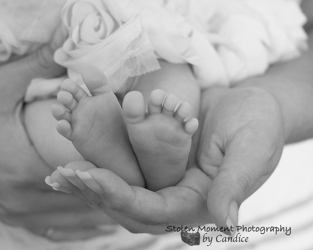 Baby's tiny feet in mom's hands