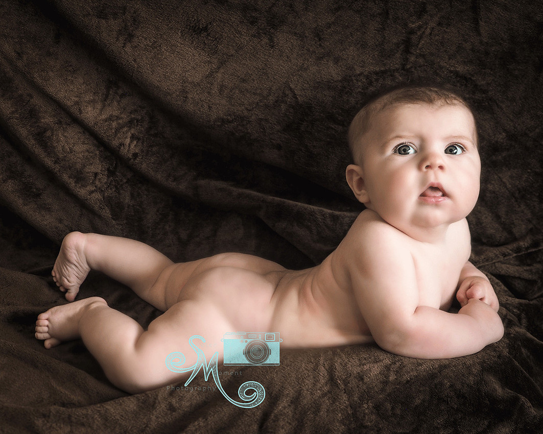 baby laying on stomach looking up at camera