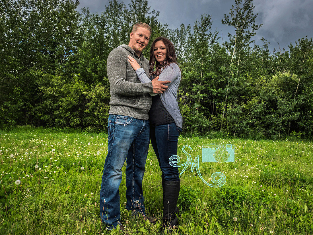 couple standing in front of trees