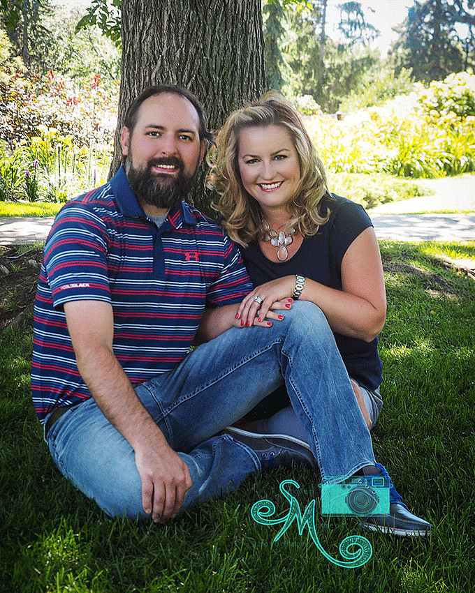a couple sitting in front of tree
