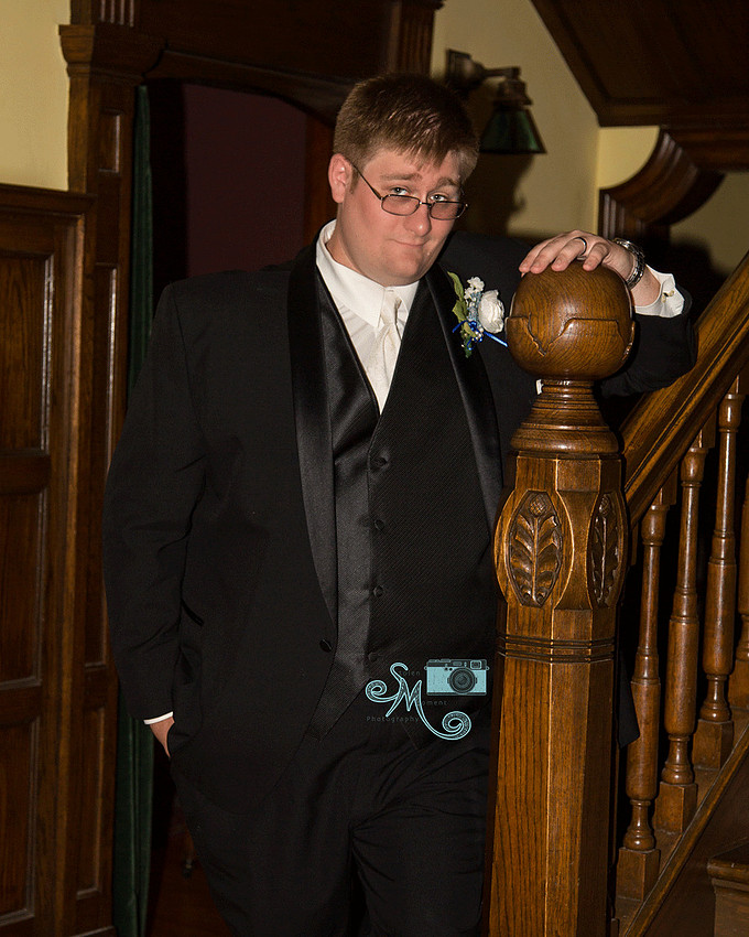 Groom standing by stairs of Rutherford