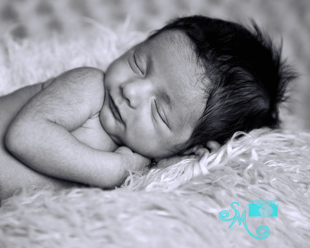 a newborn baby boy smiling in his sleep