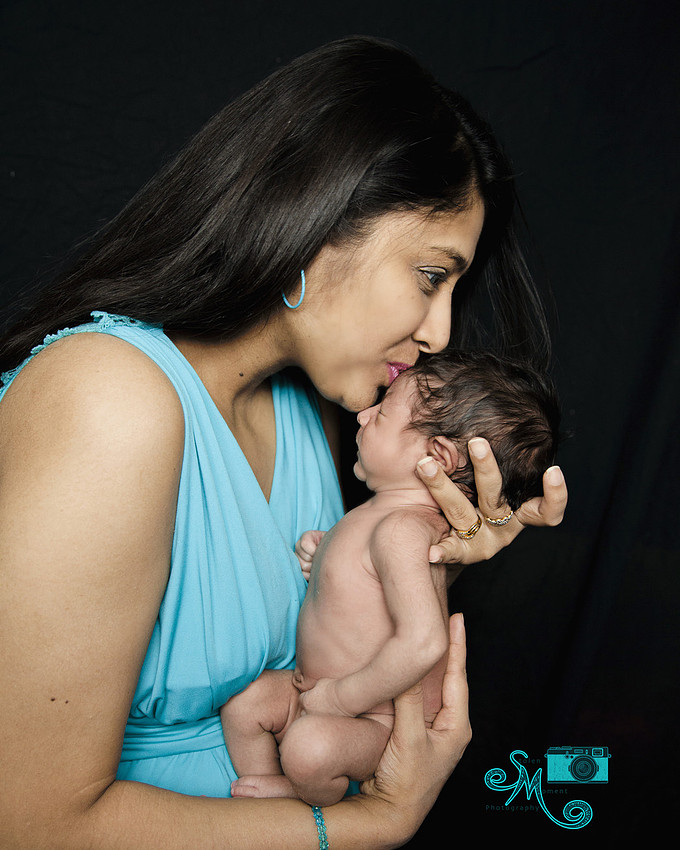 a new mom kisses her newborn son on his forehead