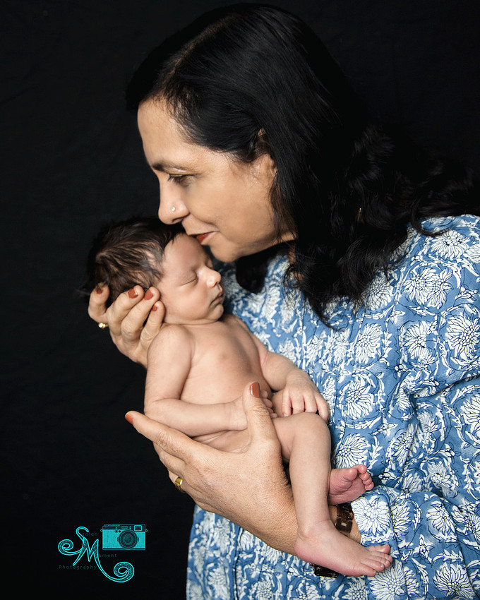 A grandma kisses her grandson on his forehead