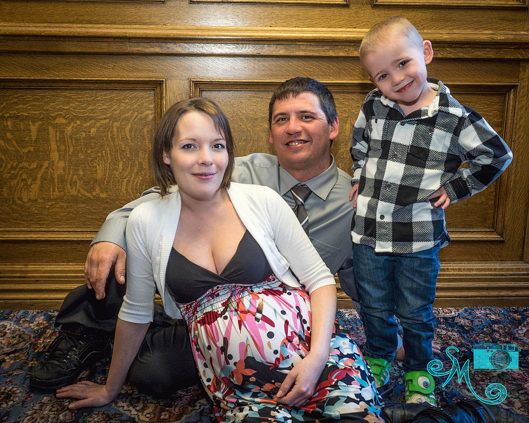 a mom, dad and big brother to be sit on the floor 