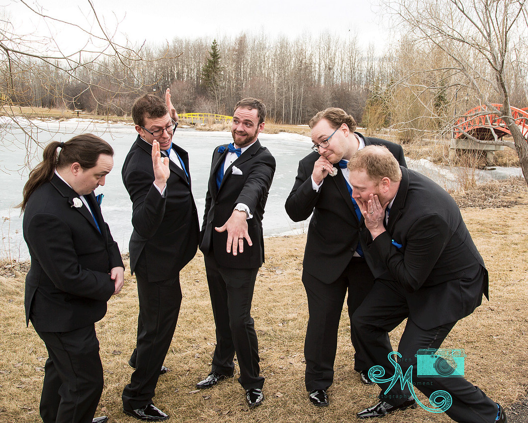 the groom shows off his ring to his groomsmen