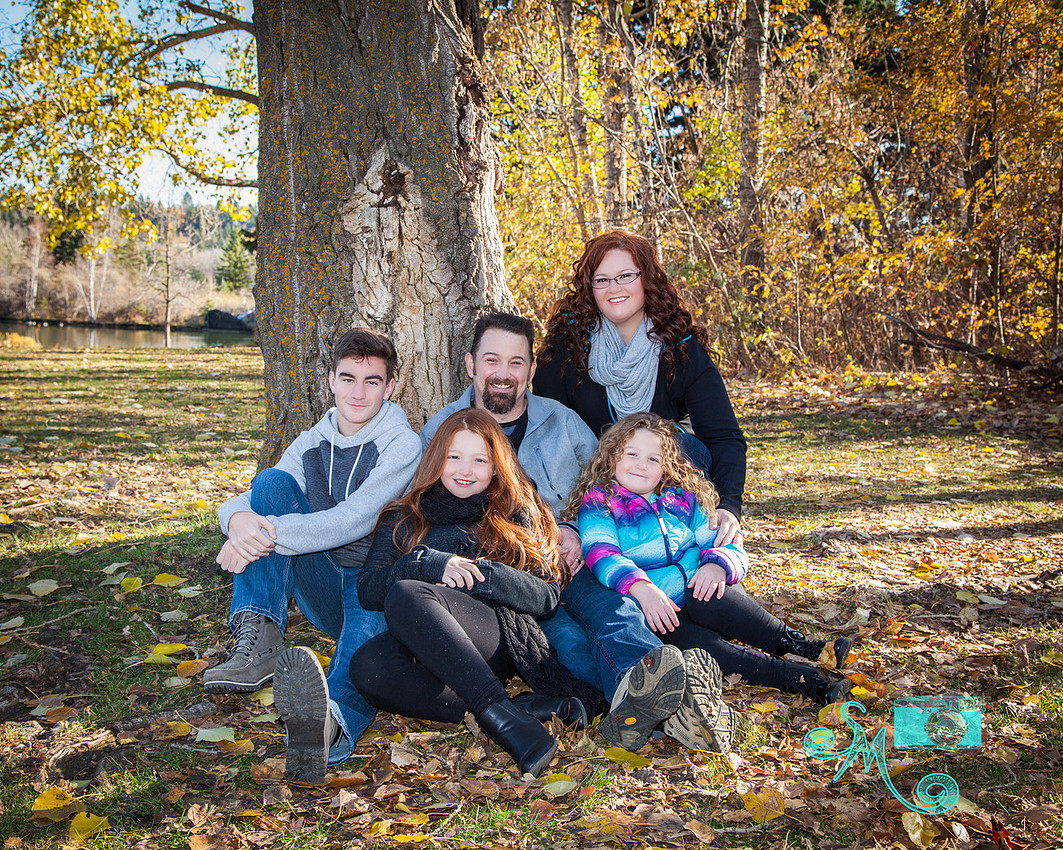mom, dad and three children pose amongst the fall leaves at Hawrelak park