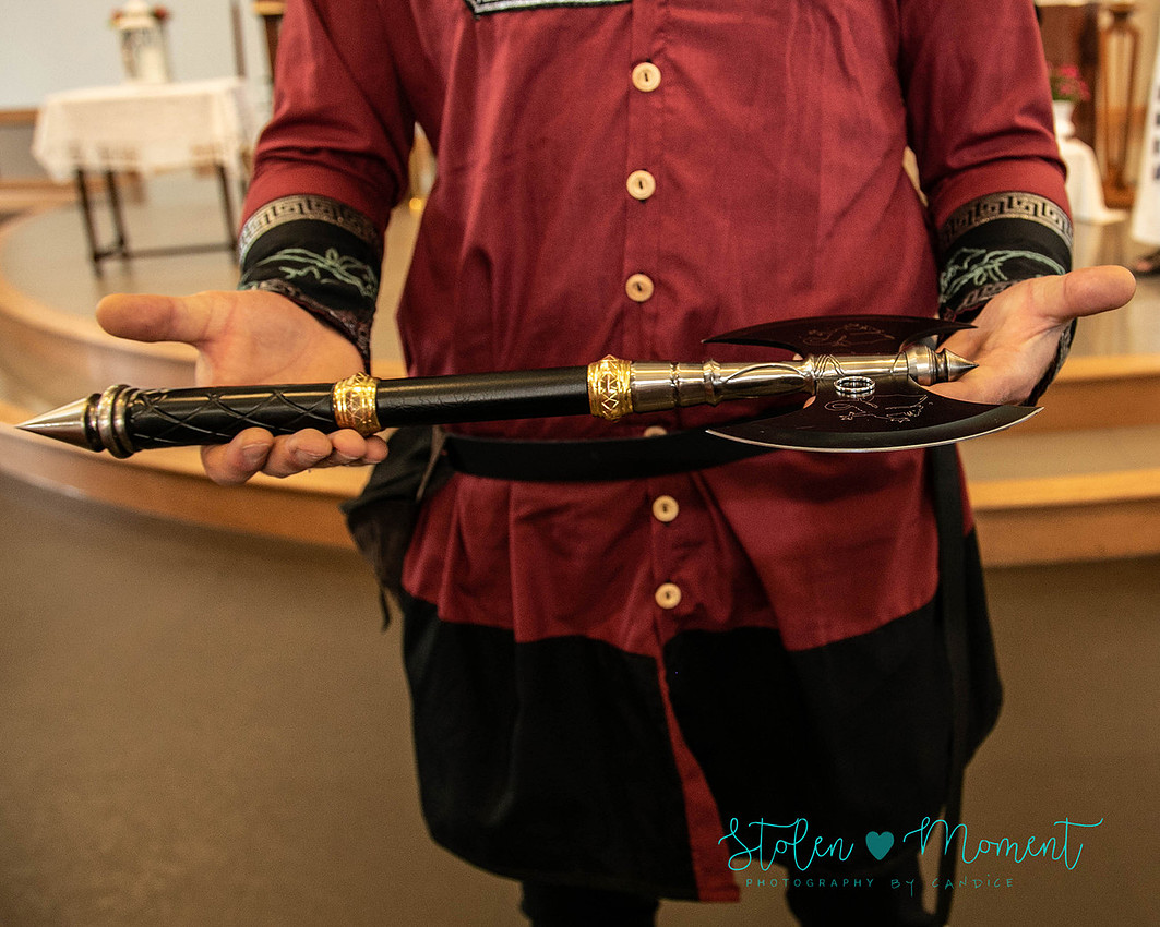 the bride's ring is presented by a guard on a dagger