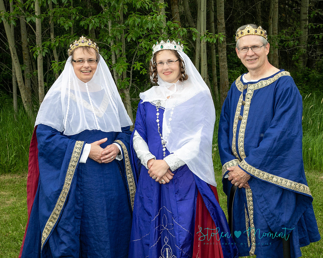 a bride stands with her mother and father - all of whom are dressed in traditional fourteenth century costumes