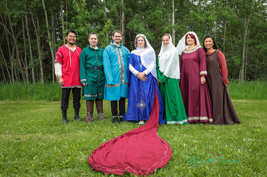 the bride stands with her six siblings all of whom are dressed in fourteenth century costume
