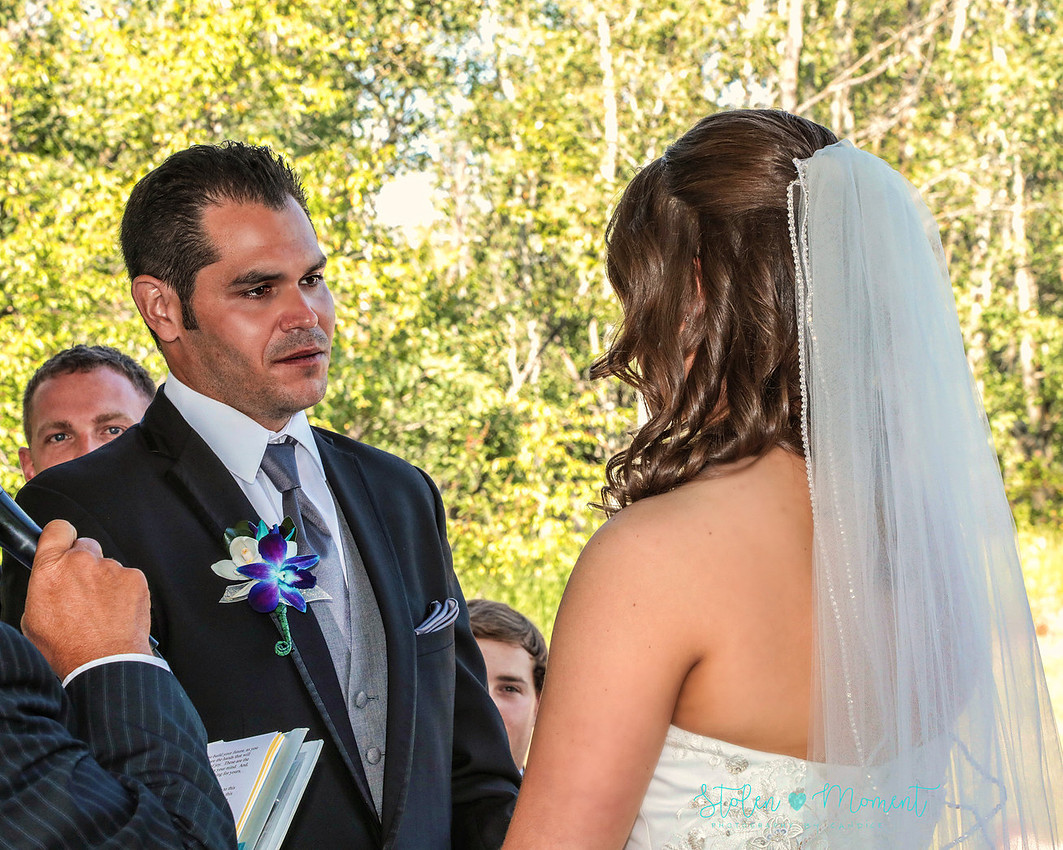 the groom looks into his bride's eyes as he says his vows