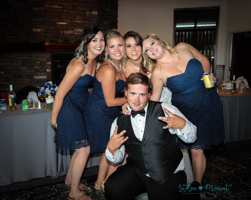the bride with three of her bridesmaids and one groomsmen strike a fun shot during the reception 