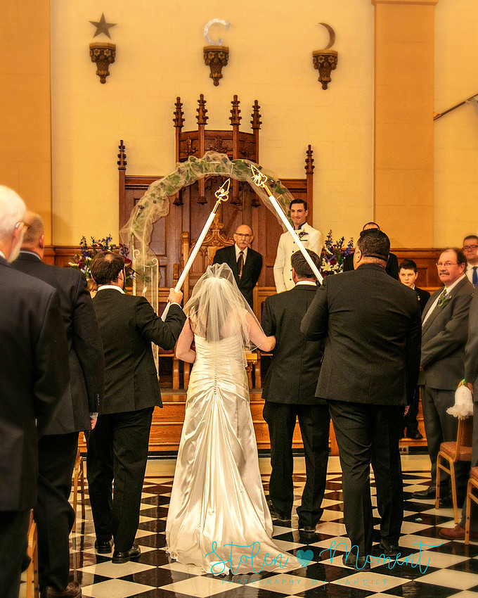 a bride in an elegant wedding dress and a groom in a white Indian suit are married at The Freemason hall in Edmonton with formals at Government House and Roger's Place on a snowy September day.