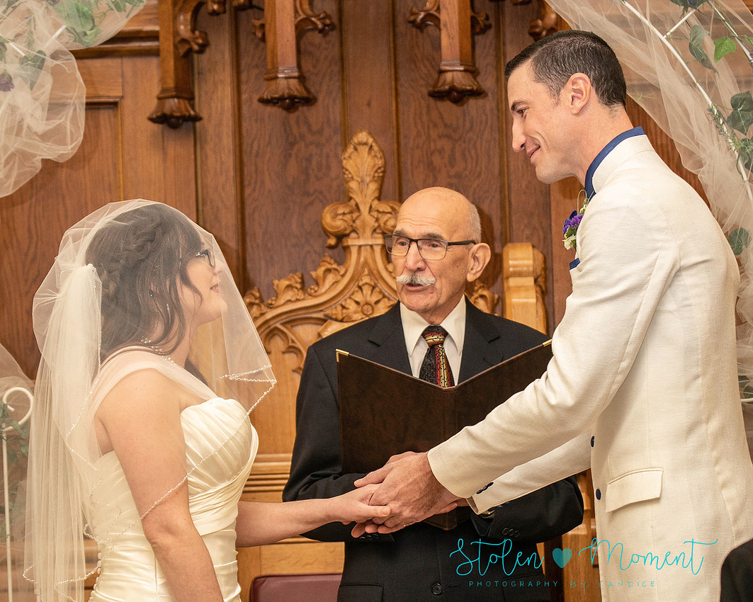 a bride in an elegant wedding dress and a groom in a white Indian suit are married at The Freemason hall in Edmonton with formals at Government House and Roger's Place on a snowy September day.