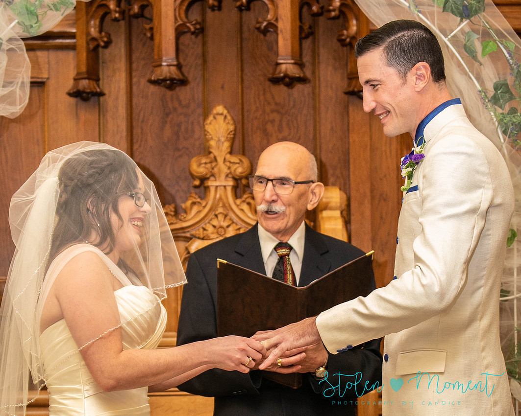 a bride in an elegant wedding dress and a groom in a white Indian suit are married at The Freemason hall in Edmonton with formals at Government House and Roger's Place on a snowy September day.