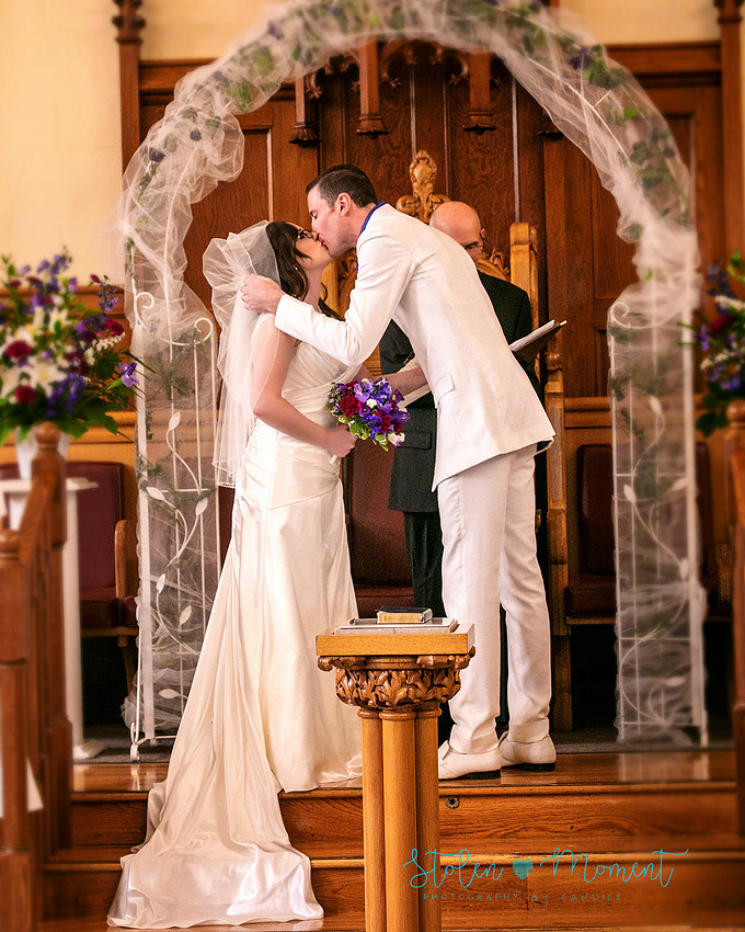 a bride in an elegant wedding dress and a groom in a white Indian suit are married at The Freemason hall in Edmonton with formals at Government House and Roger's Place on a snowy September day.