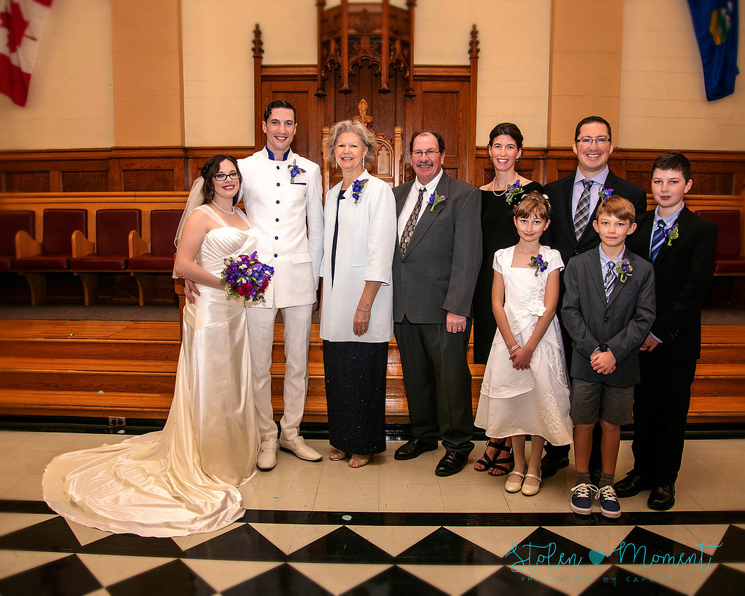 a bride in an elegant wedding dress and a groom in a white Indian suit are married at The Freemason hall in Edmonton with formals at Government House and Roger's Place on a snowy September day.