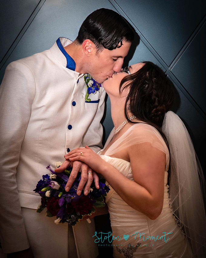 a bride in an elegant wedding dress and a groom in a white Indian suit are married at The Freemason hall in Edmonton with formals at Government House and Roger's Place on a snowy September day.