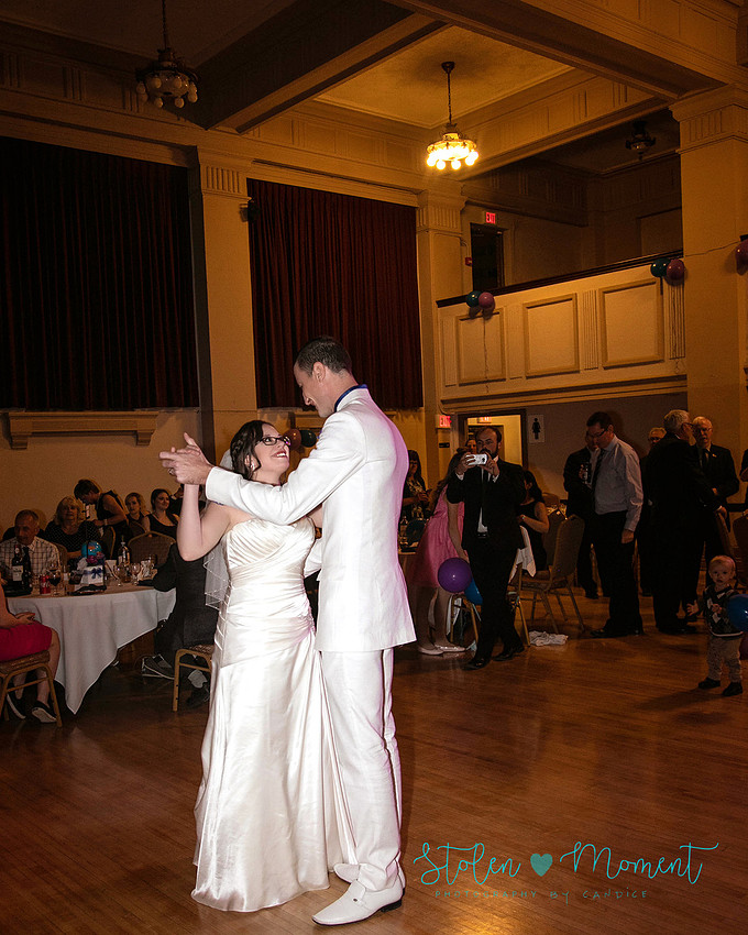 a bride in an elegant wedding dress and a groom in a white Indian suit are married at The Freemason hall in Edmonton with formals at Government House and Roger's Place on a snowy September day.
