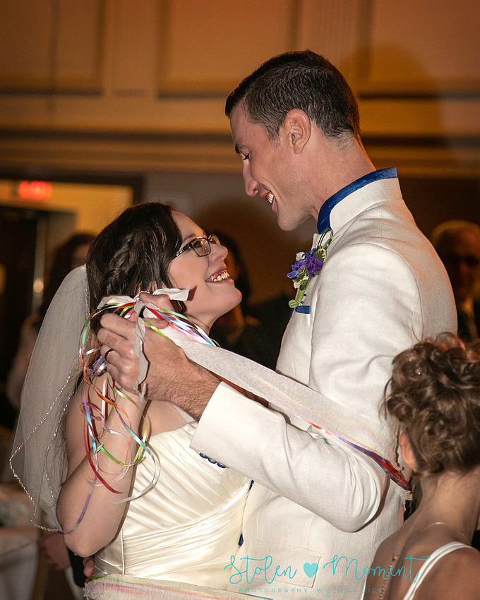 a bride in an elegant wedding dress and a groom in a white Indian suit are married at The Freemason hall in Edmonton with formals at Government House and Roger's Place on a snowy September day.