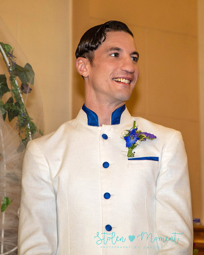a bride in an elegant wedding dress and a groom in a white Indian suit are married at The Freemason hall in Edmonton with formals at Government House and Roger's Place on a snowy September day.