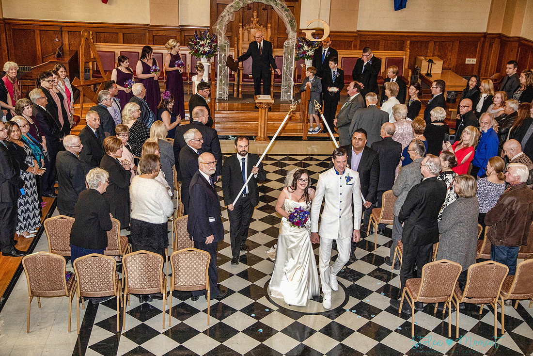 a bride in an elegant wedding dress and a groom in a white Indian suit are married at The Freemason hall in Edmonton with formals at Government House and Roger's Place on a snowy September day.