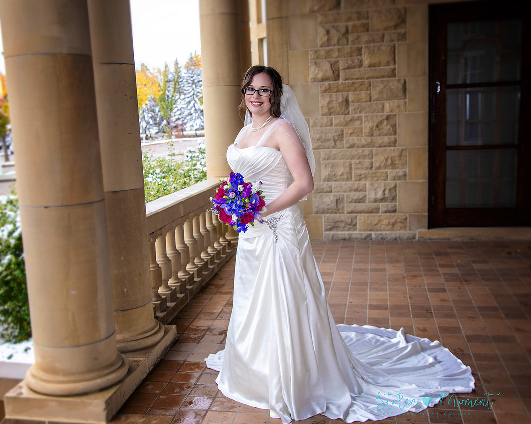 a bride in an elegant wedding dress and a groom in a white Indian suit are married at The Freemason hall in Edmonton with formals at Government House and Roger's Place on a snowy September day.