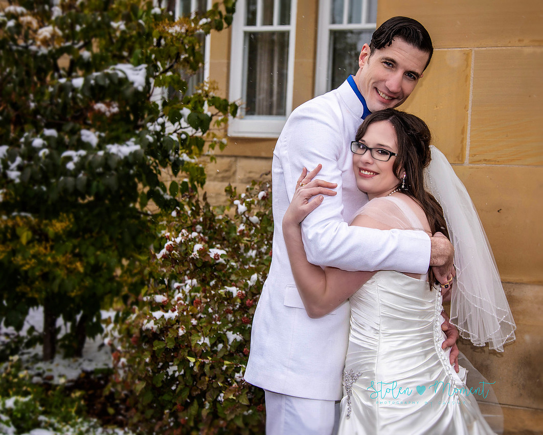 a bride in an elegant wedding dress and a groom in a white Indian suit are married at The Freemason hall in Edmonton with formals at Government House and Roger's Place on a snowy September day.
