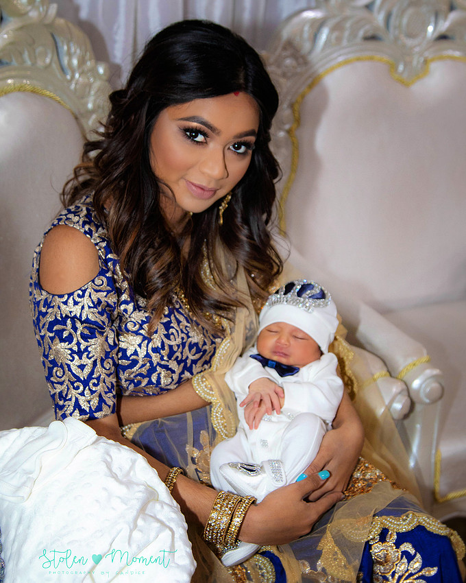 mom, dad and family celebrate the birth of a seven day old baby with hindu traditions.