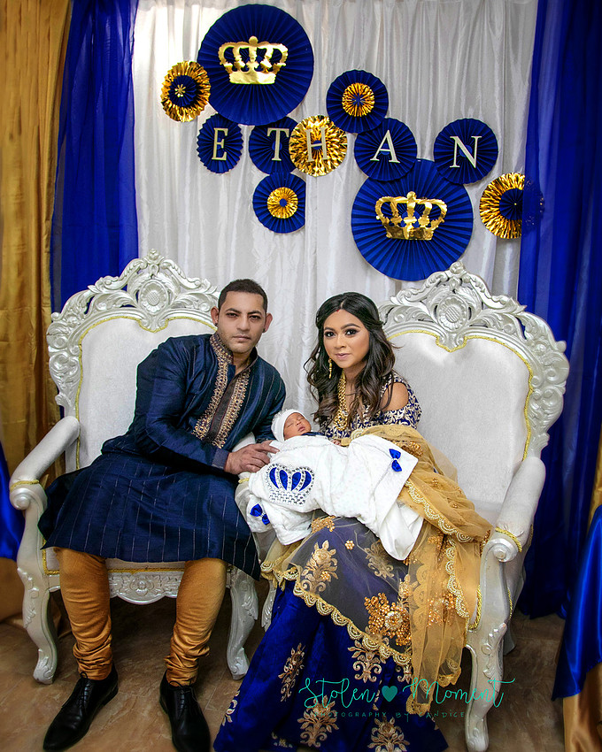 mom, dad and family celebrate the birth of a seven day old baby with hindu traditions.