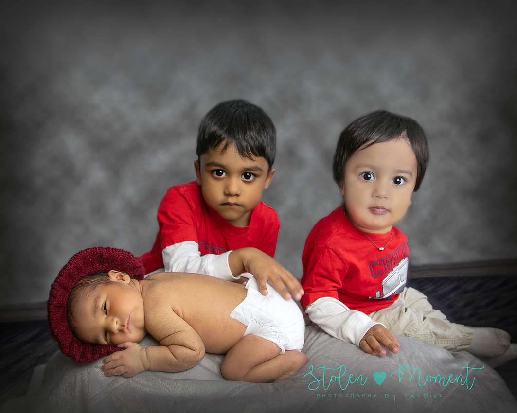 8 day old boy with his two older brothers and his beautiful mom