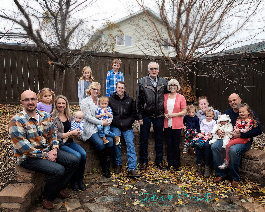 Family of fifteen photographed on a chilly fall afternoon in a Stony Plain backyard.