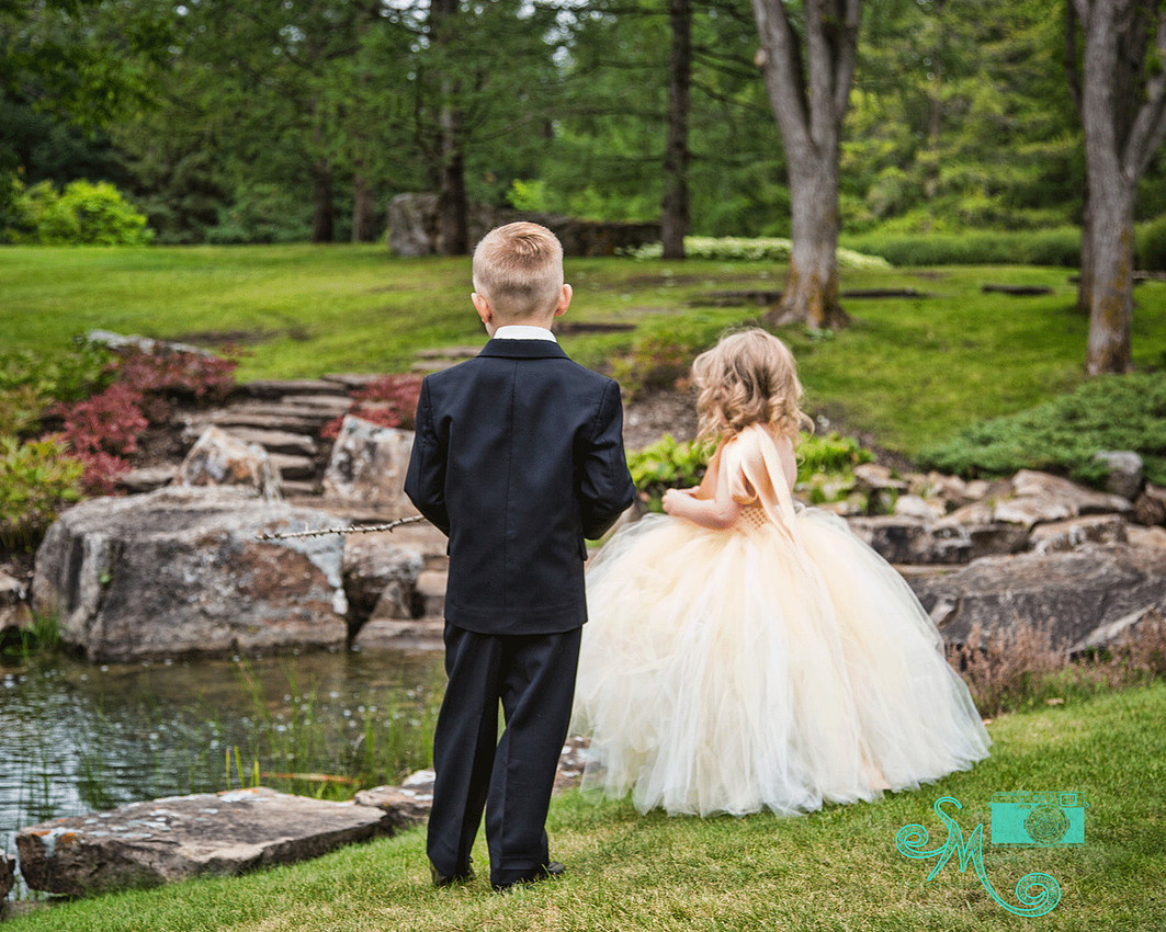 ring bearer and flower girl standing looking at water
